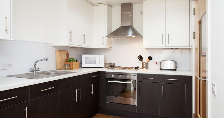 the shared kitchen at tramworks featuring a sink, microwave, hob, oven and cupboards