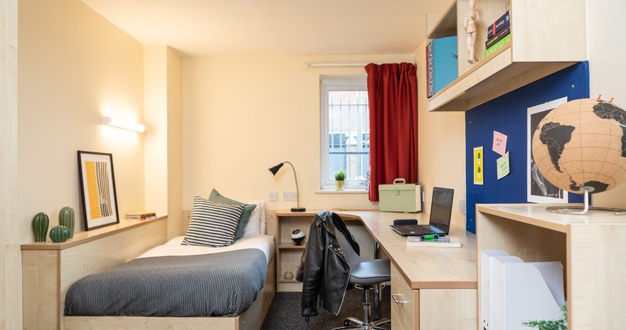 Wide shot of the classic ensuite showing a bed, study desk and window in Albert Court