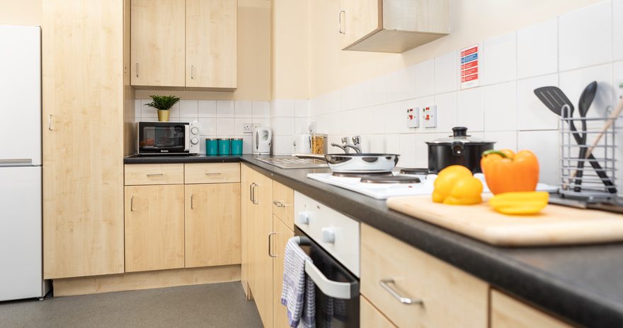 A view of the sink, hob, oven and the fridge-freezer in the shared kitchen at Albert Court