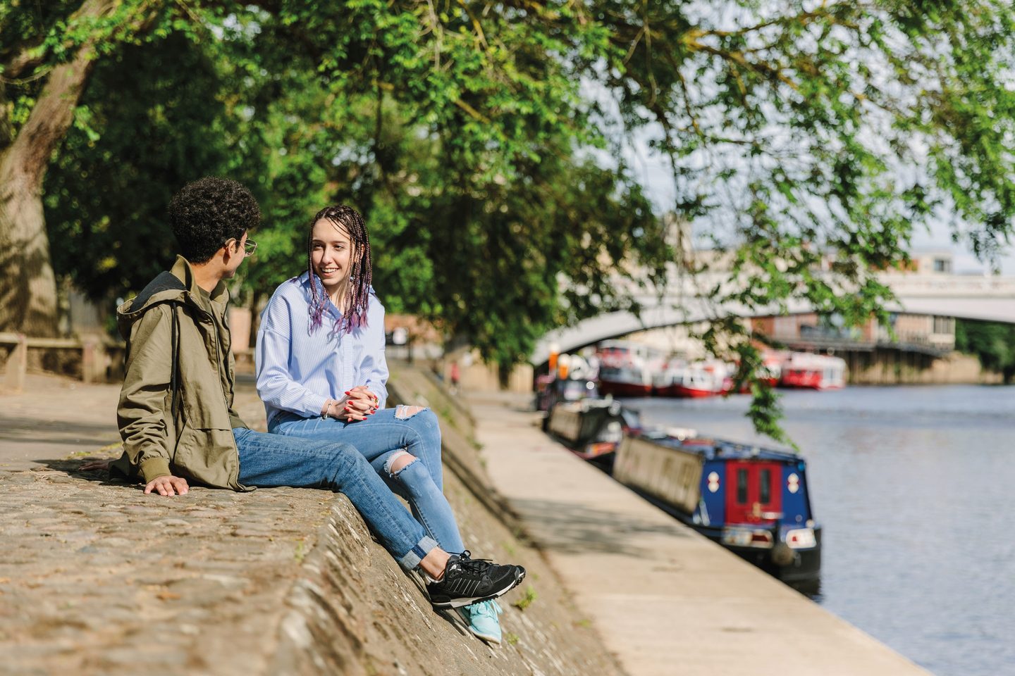 Two students chatting by the water in York