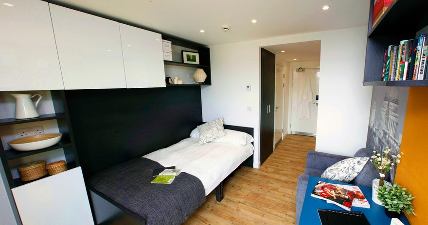The studio flat with a bed, study desk, cupboards and a small sofa at Urbanest Tower Bridge in London