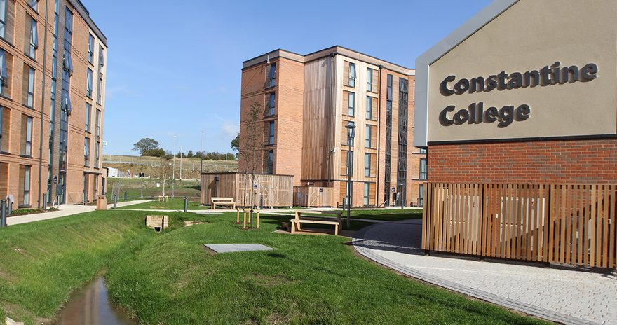 the constantine college buildings with a garden and benches