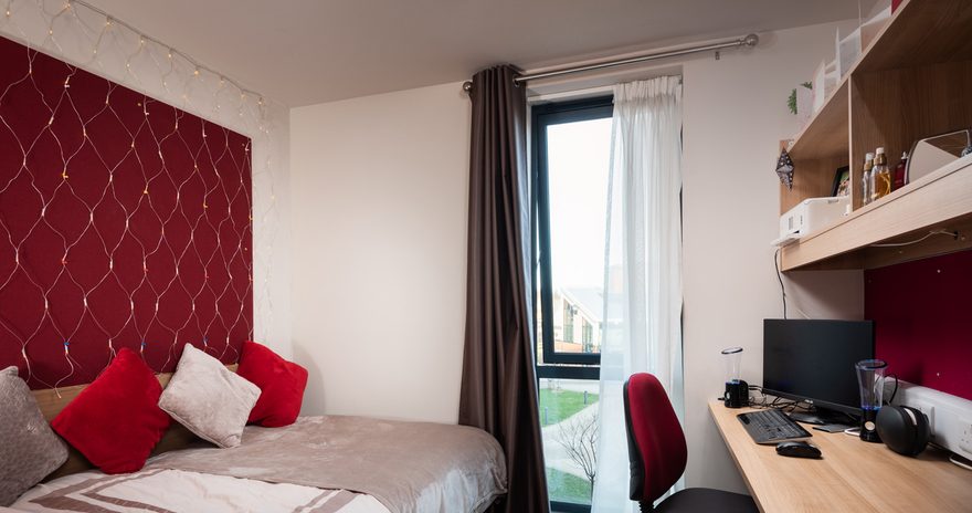 the bed and study desk in the premium ensuite at constantine college