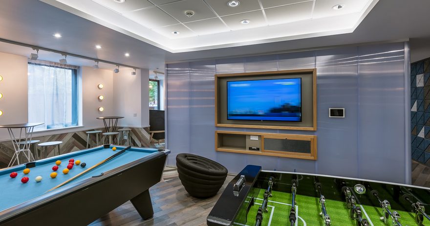 A social space at West Village featuring a pool table and table football