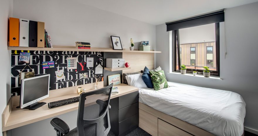 A study desk, a chair and a bed next to the window at west village accommodation