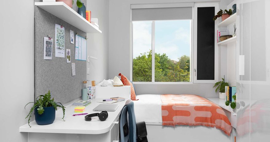 The standard ensuite at Scape Canada Water with a study desk, bed and window