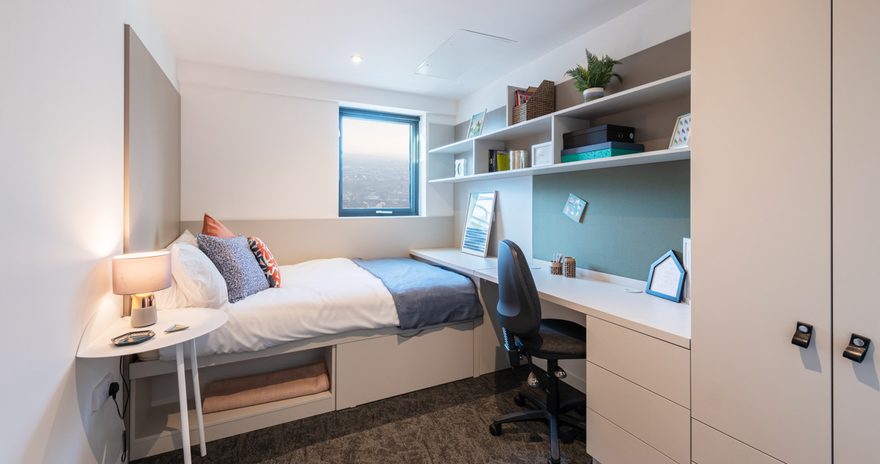 The standard ensuite at Vega with a study desk, bed and window