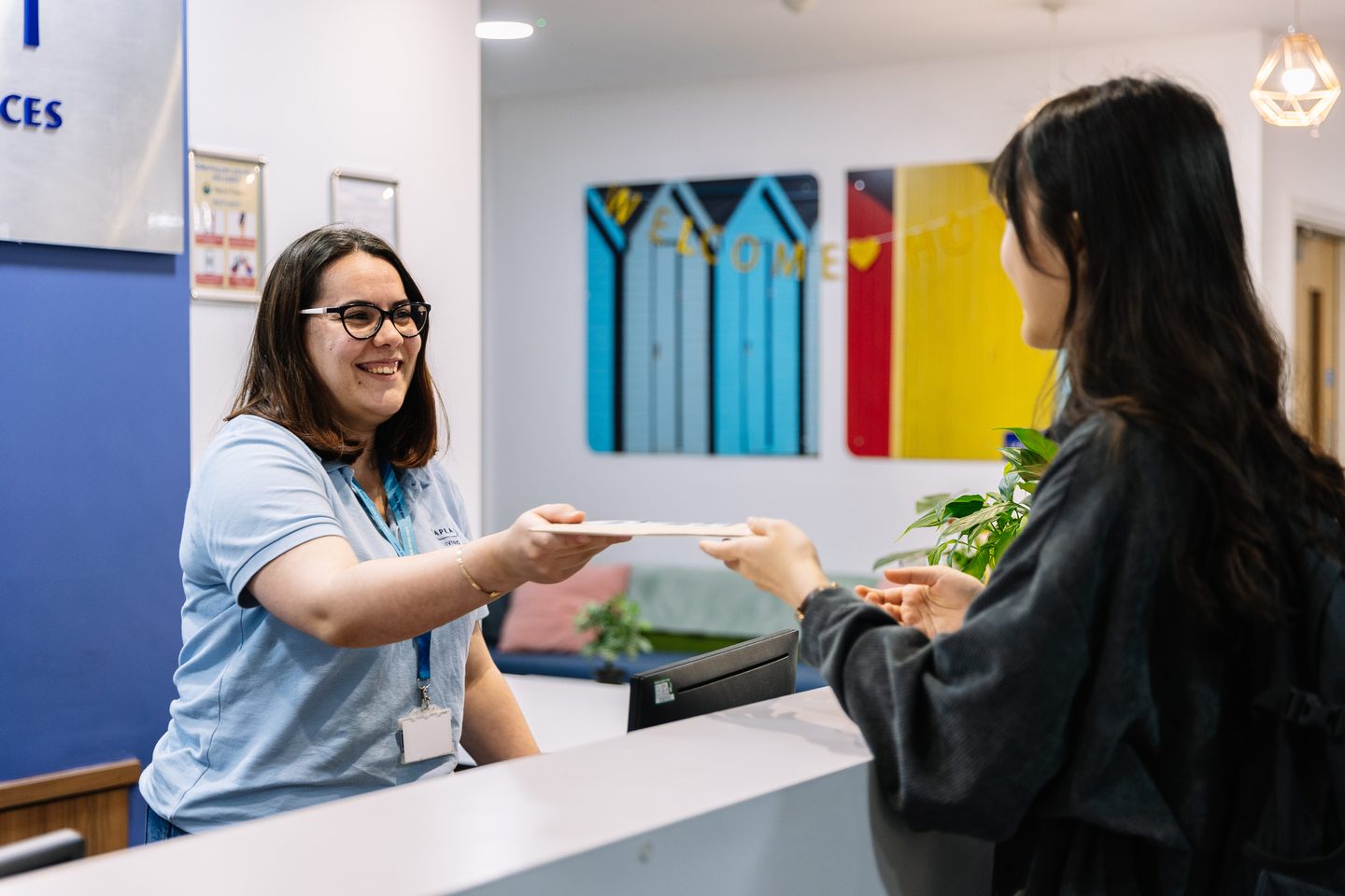 A Kaplan Living employee greeting a student