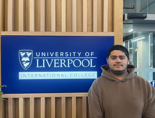 UoLIC student Hamad AlMuhannadi posing next to the university sign